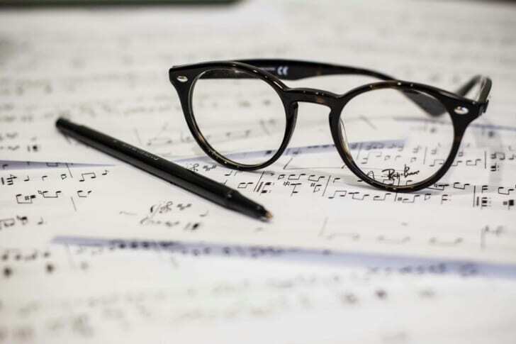 音楽祭で使う楽譜の上に眼鏡とペンが置いてある写真