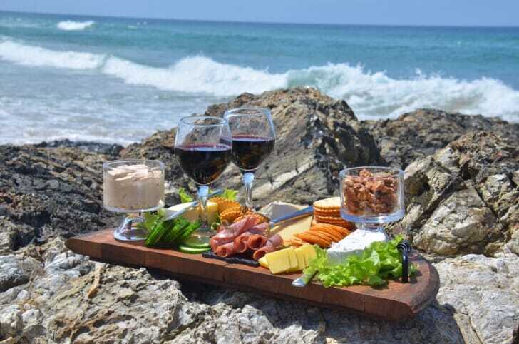 海岸に置かれたワインと食事の写真