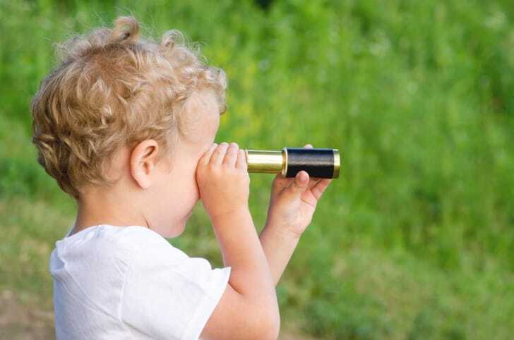 単眼鏡を覗く子供の写真