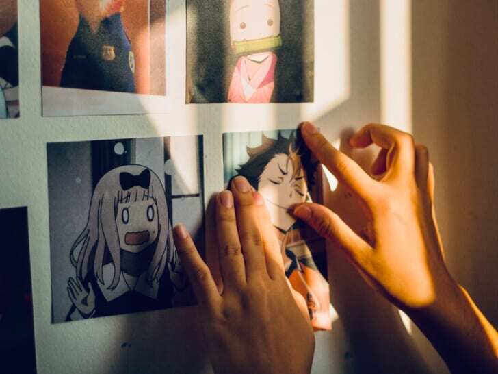 女性向けアニメのポストカードを壁に貼る写真