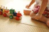 畳の部屋で子供がおもちゃで遊んでいる写真