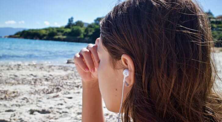 イヤホンで音楽を聴いている女性の写真