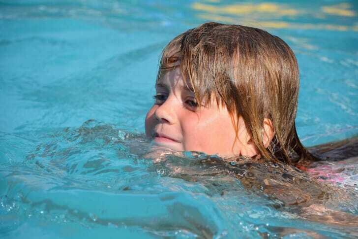 プールで気持ちよさそうに泳ぐ子供の写真