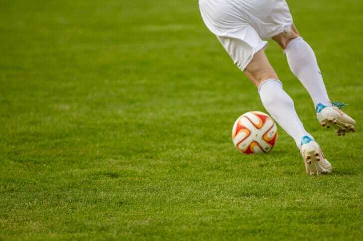 ボールを蹴るサッカー選手の写真