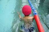 水泳帽をかぶって泳いでいる小学生の写真