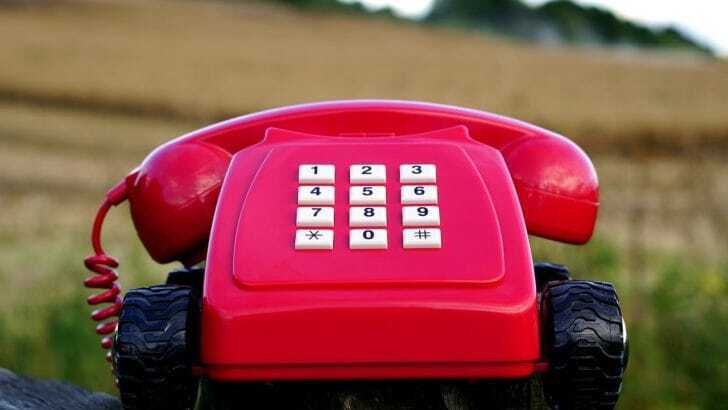 草原に赤い電話が置いてある写真