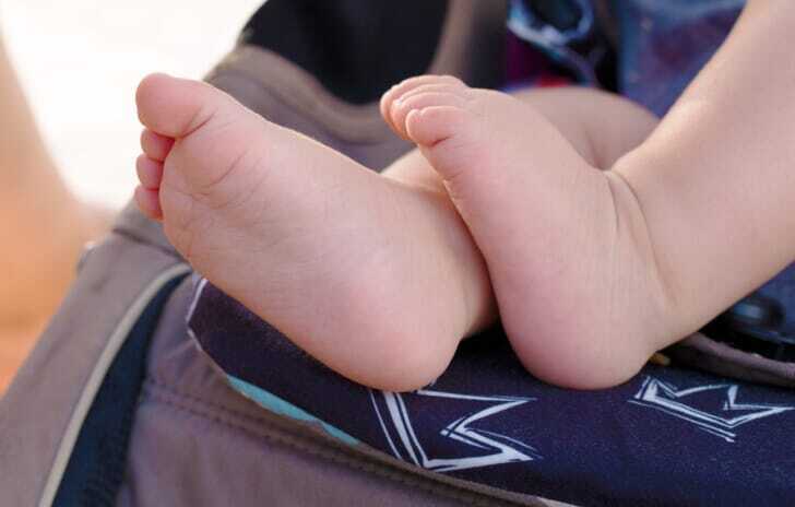 ベビーカーに乗っている赤ちゃんの脚が写っている写真