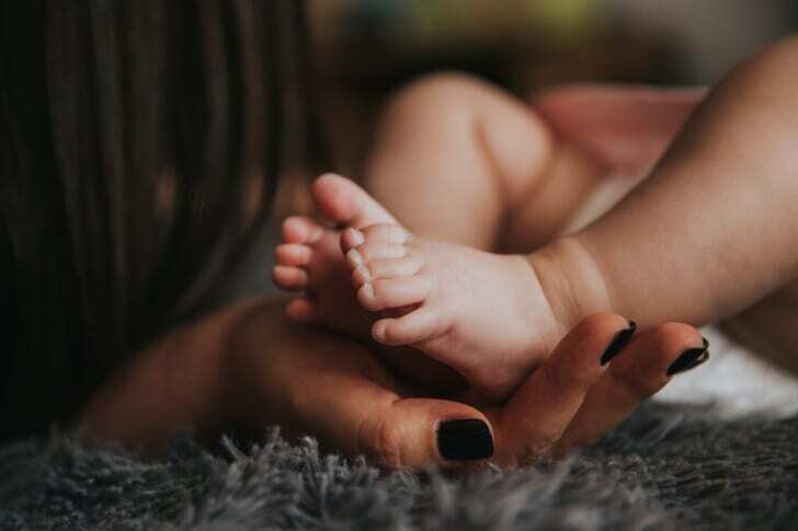 赤ちゃんの足とそれを支える手の写真