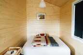 木製の壁にフレームなしのベッドが置かれている画像