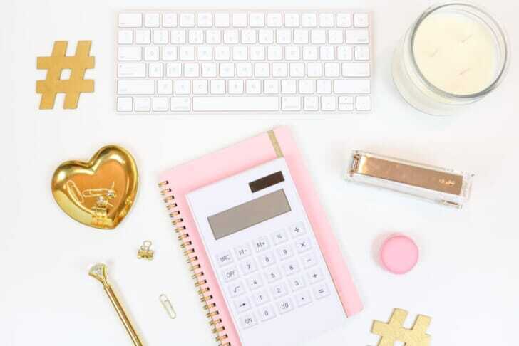 pink and white calculator beside silver and gold key