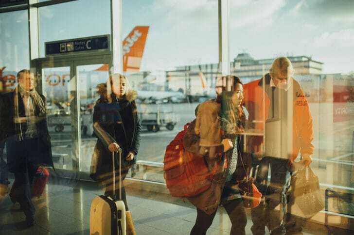 空港でスーツケースを持って歩く人々の画像