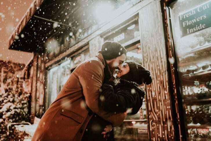 雪の中で抱きしめ合い喜ぶ男女