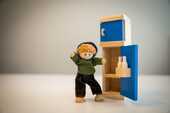 木製の冷蔵庫と人形の男の子の写真