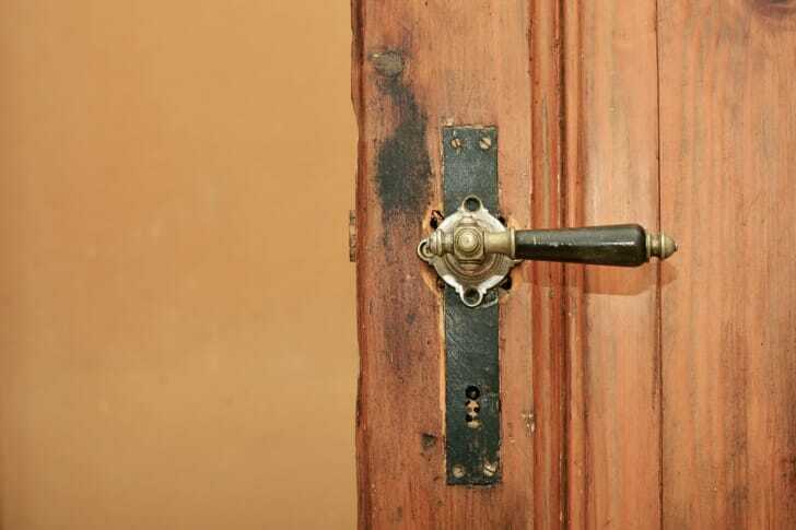 ハンドルタイプのドアノブがついた木製のドアの画像