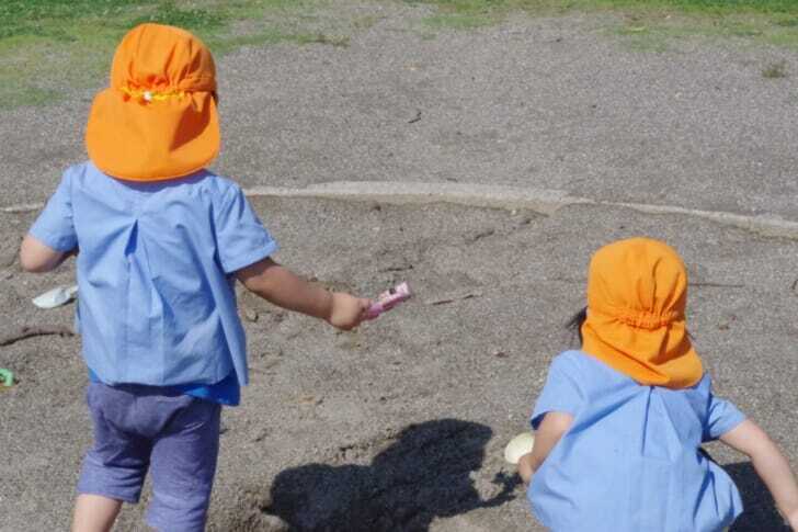 幼稚園スモックを着て遊んでいる子供たちの写真