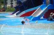 プールのウォータースライダーで遊ぶ子供の写真