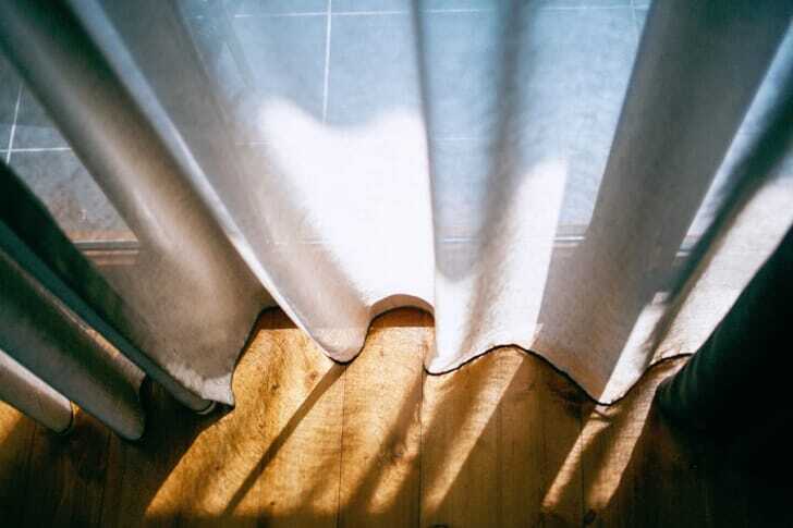 カーテンから陽の光が透けている写真