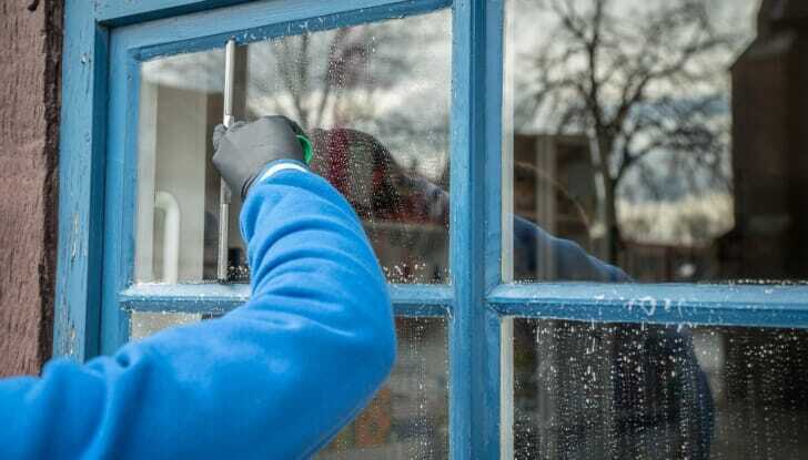 スクイジーで窓を掃除している人の写真