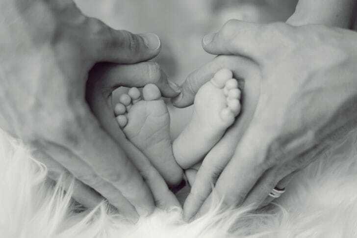 赤ちゃんの足と父母の手の画像