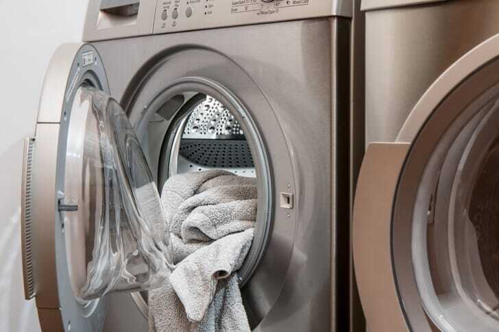 洗濯物が飛び出ている洗濯機の写真