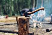 キャンプで手斧で木を割っている写真