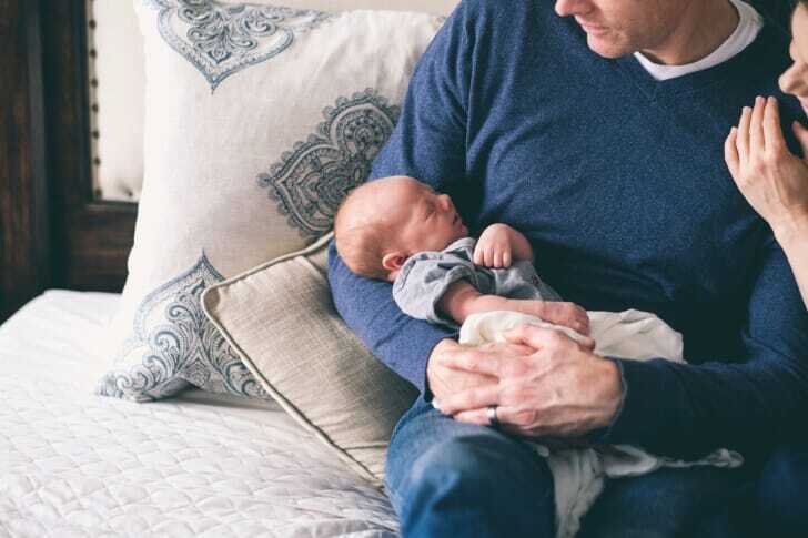 赤ちゃんがパパの腕の中で寝ている写真