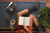 靴下を履いた女性が本を読んでいる写真