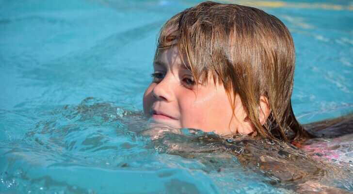 プールで気持ちよさそうに泳ぐ子供の写真