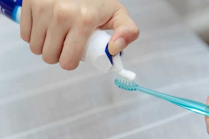 歯ブラシに歯磨き粉をつけている写真