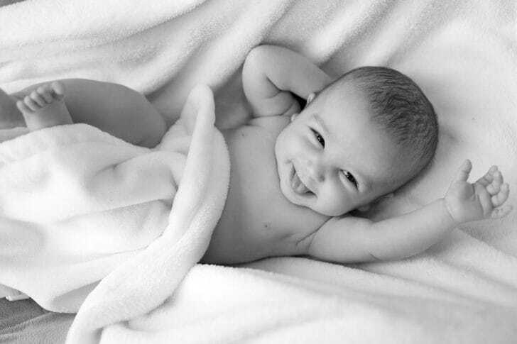 毛布に寝そべっている赤ちゃんの画像