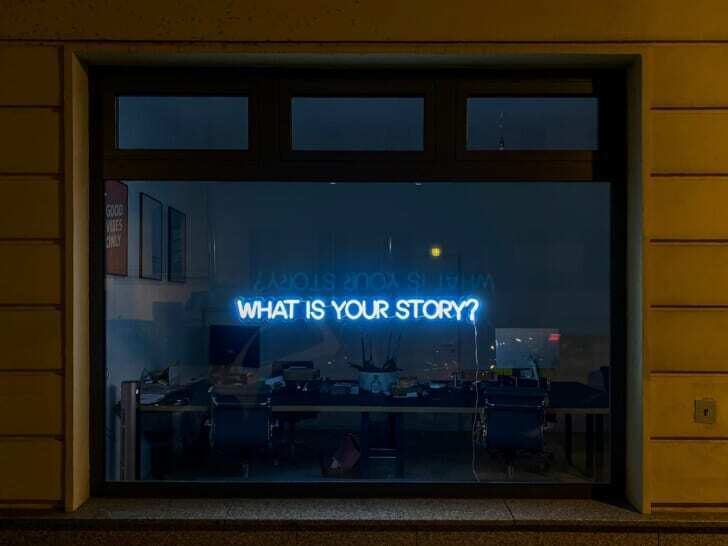 英語で「WHAT IS YOUR STORY」と質問が書いてあるネオンサインの写真