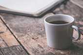 机の上にコーヒーの入ったマグカップがある写真
