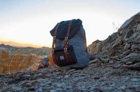 gray and black backpack on top of cliff