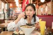福岡名物のとんこつラーメンを食べる女性の写真