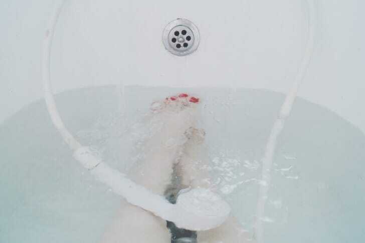 風呂に浸かっている女性とシャワーの写真