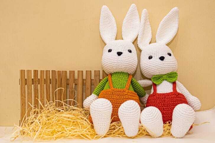 white rabbit plush toy on brown hay