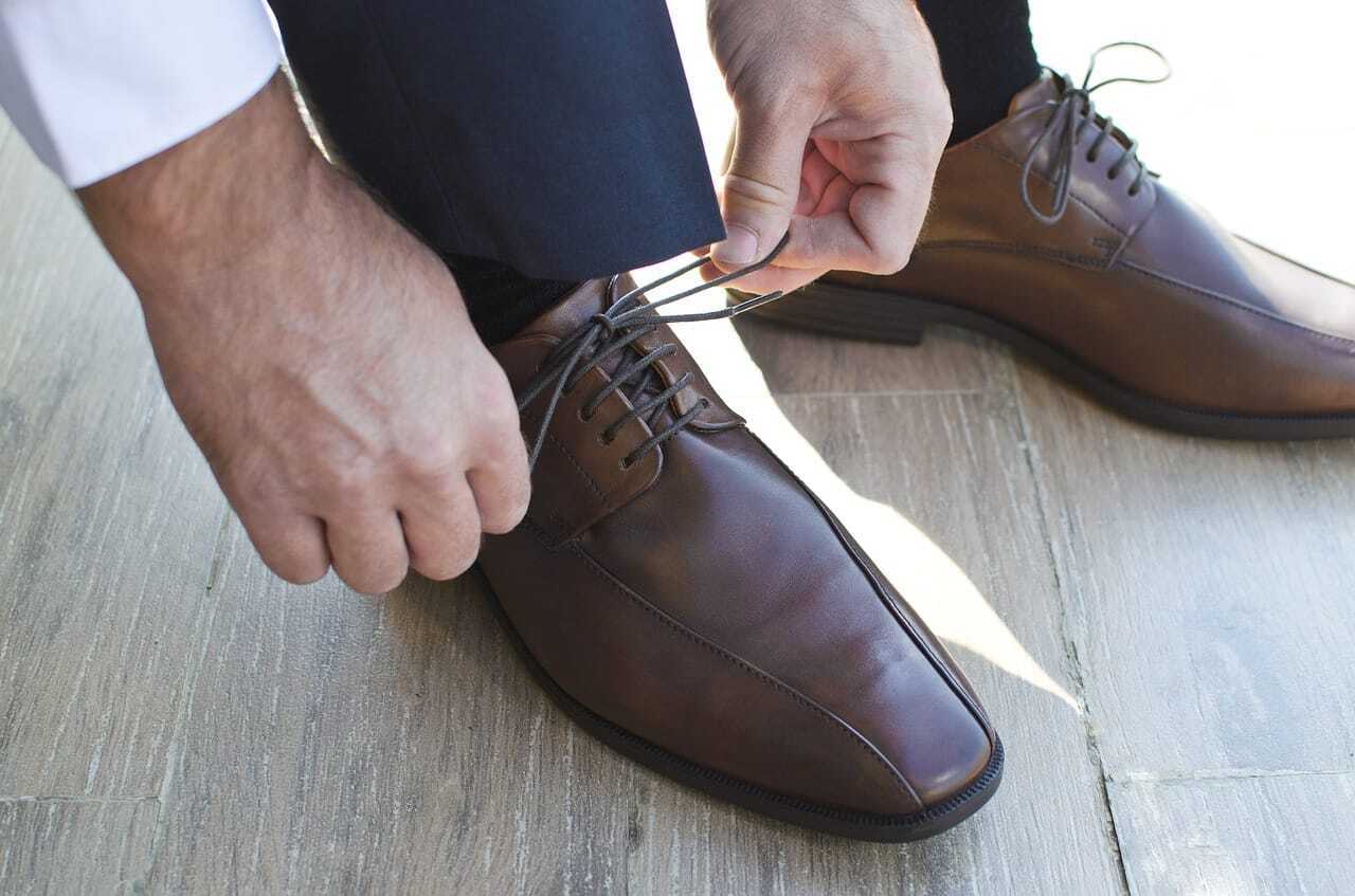 男性が靴紐を結ぶ写真