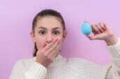 woman in white sweater holding blue balloon