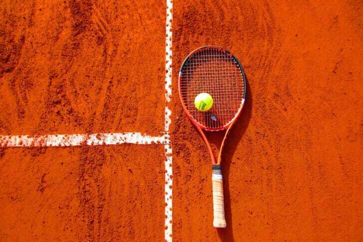 テニスコートにラケットとボールが置かれている画像