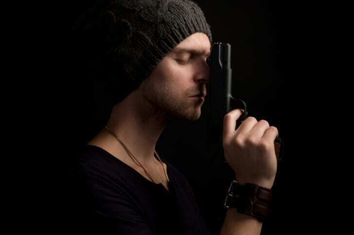 スパイらしき男が銃を構えて祈っている写真