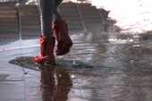 水たまりを歩く女性の脚の画像