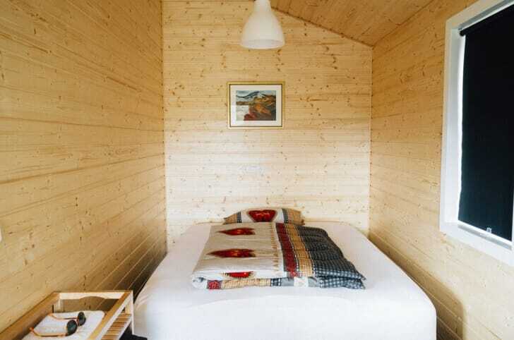 木製の壁にフレームなしのベッドが置かれている画像