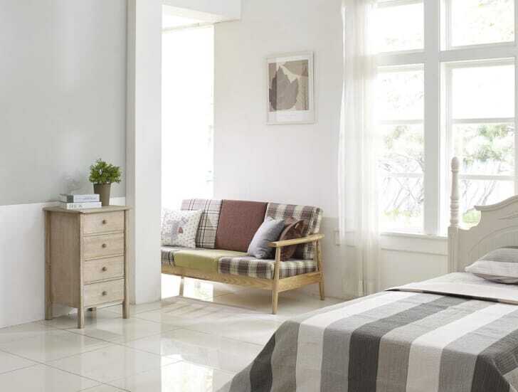 寝室の窓際に木槌のソファが置かれている画像