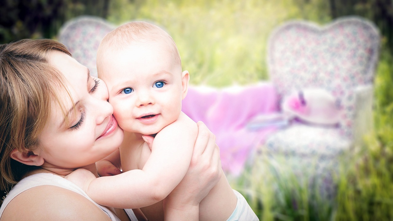 母と子供が芝生の上で抱き合っている画像