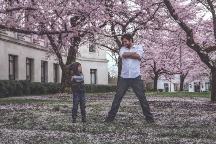 桜の木下で楽しそうにしている親子の写真
