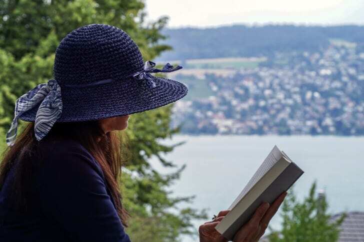 景色の良い場所で本を読む人の姿